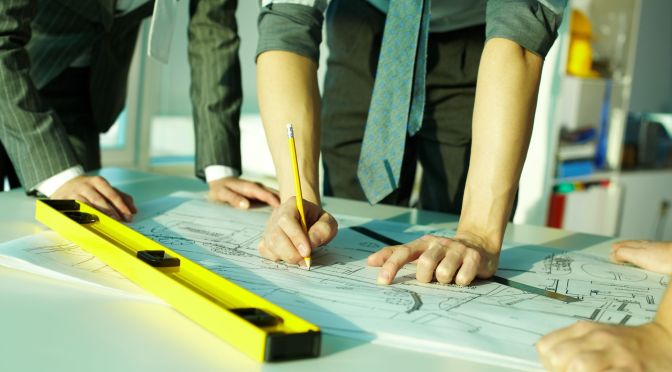 Building project design team marking up plans