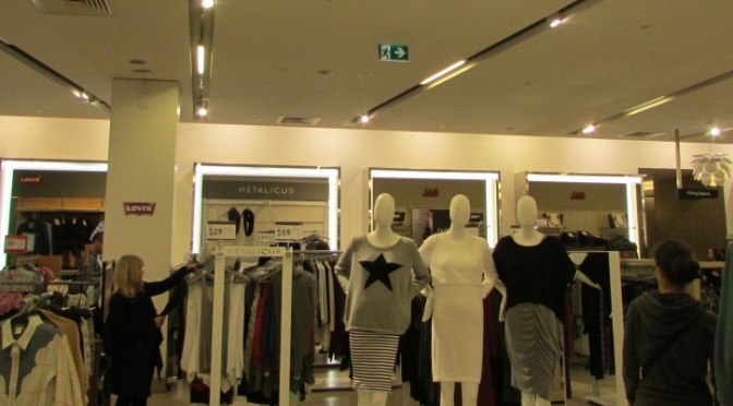 Ceiling mounted exit sign in shopping centre with running man