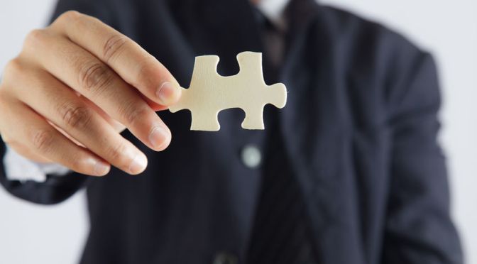 Man holding missing piece of jigsaw puzzle